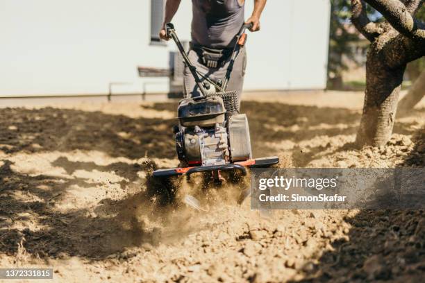man working on his yard with a motor-cultivator at home - milling cutter stock pictures, royalty-free photos & images