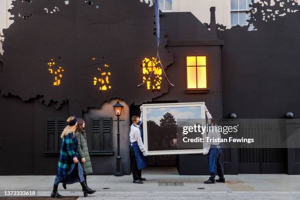 Sotheby’s technicians hold René Magritte’s masterwork, L’empire des lumières, outside the auction house’s New Bond Street entrance at Sotheby's on...