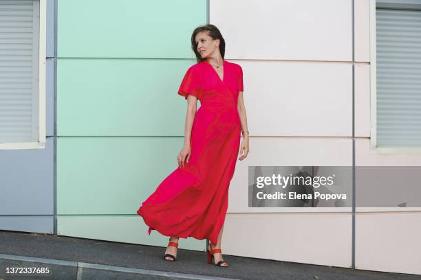 young beautiful woman in pink long dress walking on the street - long dress fotografías e imágenes de stock