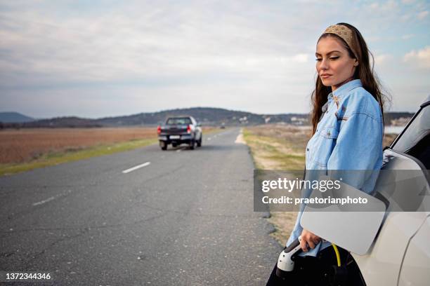 mujer desesperada con coche eléctrico sin batería está buscando ayuda - deficiencia condición fotografías e imágenes de stock