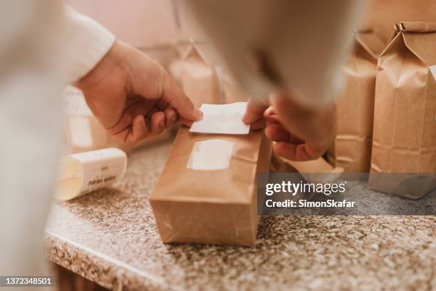 man applying label on paper bag in mill - flour packaging stock pictures, royalty-free photos & images