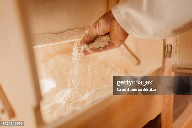 man checking flour inside wooden grinding machine - grinding stock pictures, royalty-free photos & images