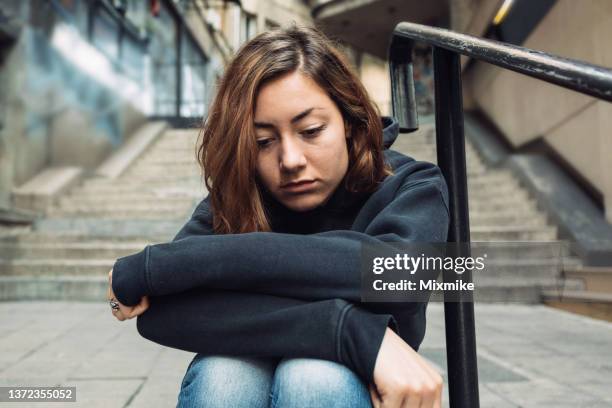 depressed girl in black hoodie - homeless youth stock pictures, royalty-free photos & images