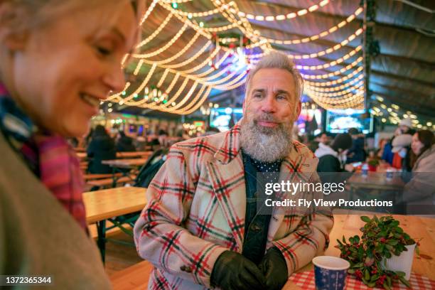 älteres touristenpaar, das lokale speisen und getränke auf dem nachtmarkt unter freiem himmel genießt - boomer couple out on town stock-fotos und bilder