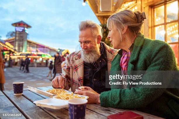 älteres touristenpaar, das street food genießt - boomer couple out on town stock-fotos und bilder