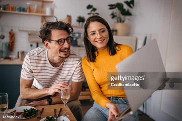 happy young couple video calling over laptop at home - virtual lunch stock pictures, royalty-free photos & images
