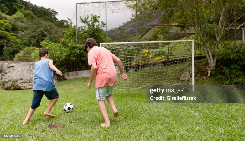 Teenager Spielen Im Sommer Zusammen Fu ball Im Garten Eines Freundes teenager-spielen-im-sommer-zusammen-fu-ball-im-garten-eines-freundes