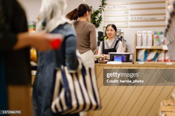 customers queuing to checkout at the counter - supermarket queue stock pictures, royalty-free photos & images