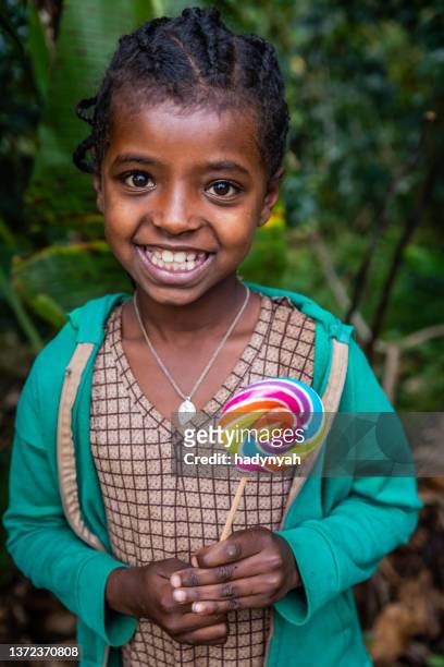 portrait of happy african little girl with a lolipop, east africa - girl lollipops stock pictures, royalty-free photos & images