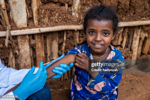 arzt injiziert junges afrikanisches mädchen in kleinem dorf in ostafrika - ethiopia fotos stock-fotos und bilder