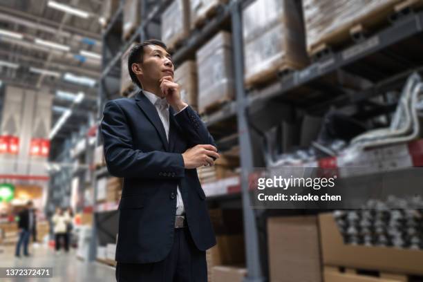 male customer in hypermarket thinking - china economy stock pictures, royalty-free photos & images