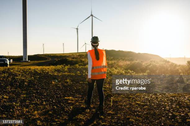 Female worker walking towards car in wind power field