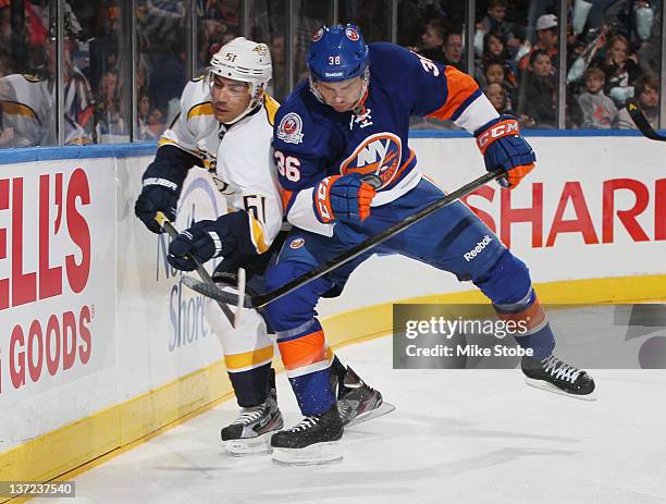 Francis Bouillon of the Nashville Predators is checked by Tim Wallace of the New York Islanders at Nassau Veterans Memorial Coliseum on January 16,...