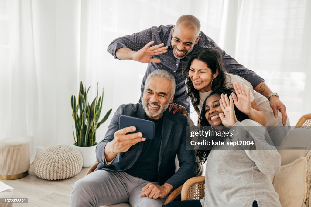 Two generation family with adult offsprings snapping photo on Th