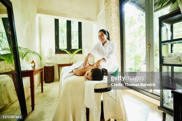 Wide shot of woman receiving massage at luxury spa
