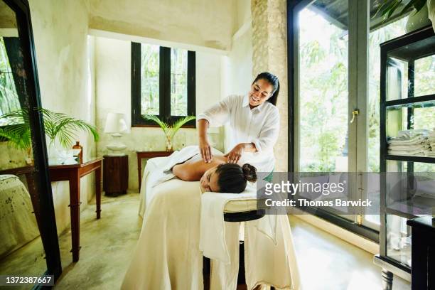 wide shot of woman receiving massage at luxury spa - massagem photos et images de collection