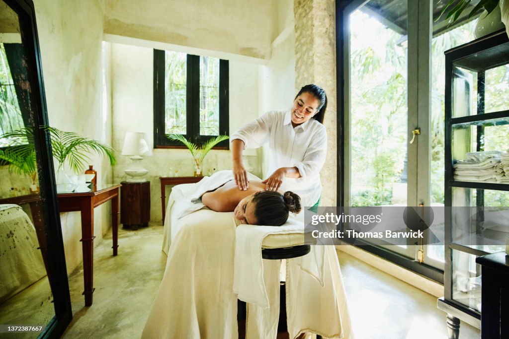 Wide shot of woman receiving massage at luxury spa
