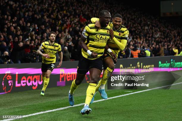 Moussa Sissoko celebrates with teammate Emmanuel Dennis of Watford FC after scoring their team's first goal during the Premier League match between...