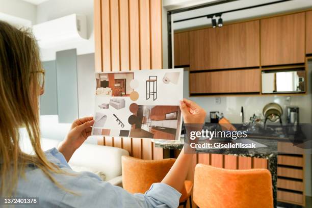 female architect looking at the picture of interior design - design kitchen stock pictures, royalty-free photos & images