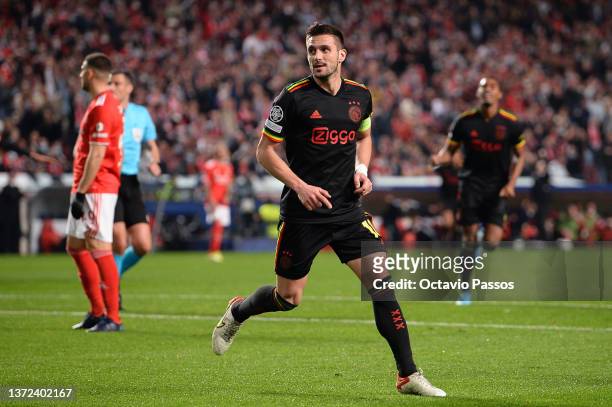 Dusan Tadic of Ajax celebrates after scoring their team's first goal during the UEFA Champions League Round Of Sixteen Leg One match between SL...