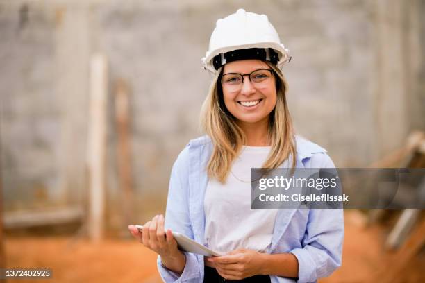 retrato de una hermosa mujer ingeniera en el sitio de construcción - gestor de proyectos fotografías e imágenes de stock