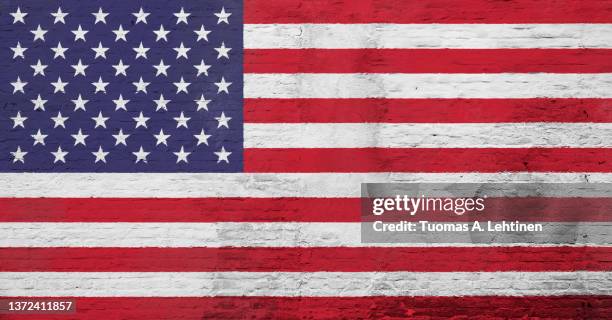 full frame photo of a weathered flag of united states (usa, us, america) painted on a plastered brick wall. - stars and stripes stockfoto's en -beelden