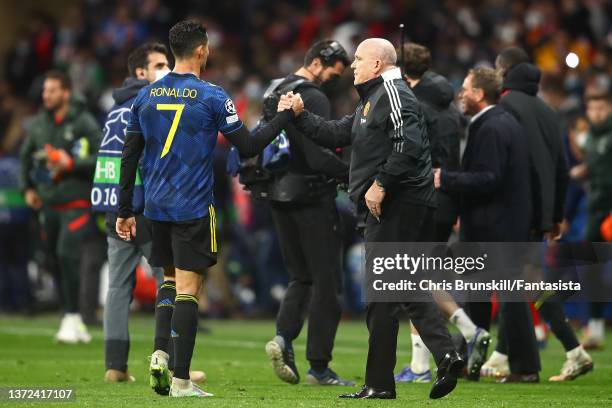 Cristiano Ronaldo of Manchester United shakes hands with coach Mike Phelan at full-time following the UEFA Champions League Round Of Sixteen Leg One...