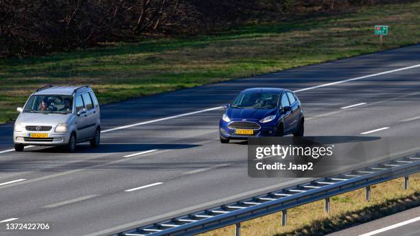 dutch blue 2015 ford fiesta  driving on the a1 highway - ford fiesta cars stock pictures, royalty-free photos & images