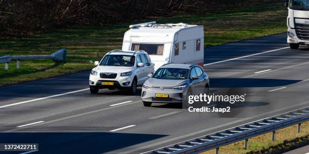 dutch hyundai santa fe with caravan + electric vw id.4 on the a1 highway - camper trailer stock pictures, royalty-free photos & images