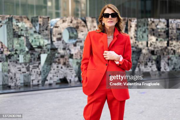 Anna dello Russo poses ahead of the Del Core fashion show wearing a red pant suit during the Milan Fashion Week Fall/Winter 2022/2023 on February 23,...