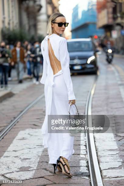 Nataly Osmann poses ahead of the Alberta Ferretti fashion show wearing a white dress, golden chain shoes and sunglasses during the Milan Fashion Week...