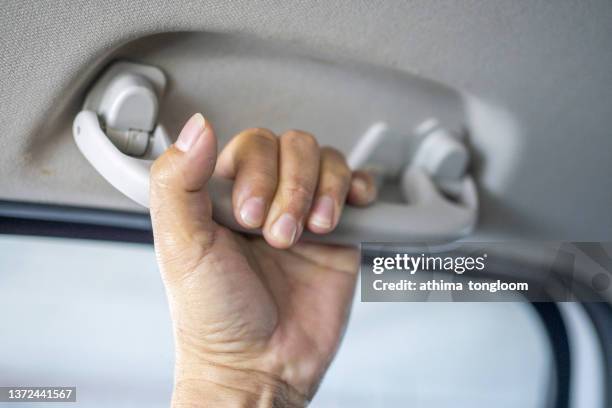 cropped human hand holding handle in the car. - handtag bildbanksfoton och bilder