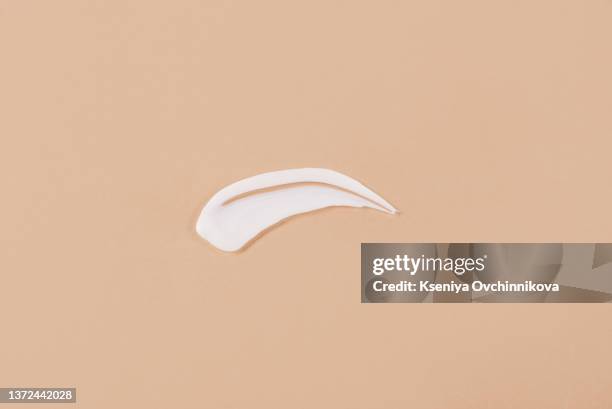 liquid cream cosmetic smudge texture gray beige background - oily skin stock pictures, royalty-free photos & images