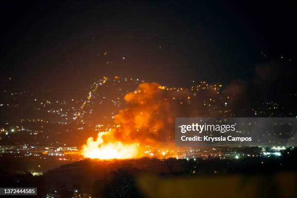 explosion and fire that can be seen in the distance at night - rubble explosion stock pictures, royalty-free photos & images