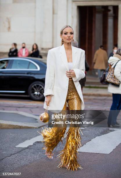 Leonie Hanne seen wearing golden glitter pants, Valentino round bag, white blazer, cropped top outside of Alberta Ferretti fashion show during the...