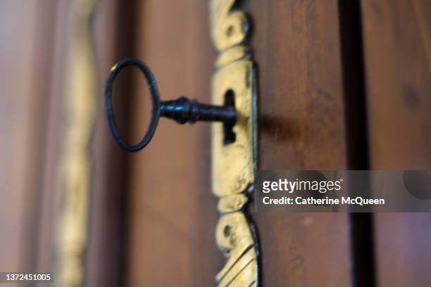 antique skeleton key in antique wooden armoire - bureau vintage stock-fotos und bilder