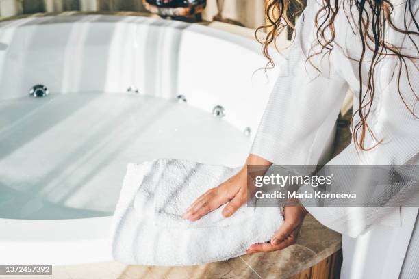 woman holding white bath towels. - bath towels stock-fotos und bilder