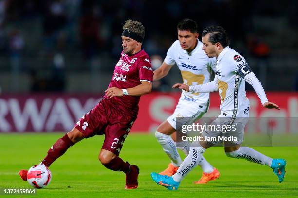 Christian Bolanos of Saprisa controls the ball against Ricardo Galindo and Alan Mozo of Pumas during the round of 16 2nd leg match between Pumas UNAM...