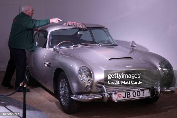 Member of the musuem team attends to a Aston Martin DB5 used in the James Bond film Goldfinger and being displayed at the Bond In Motion exhibition...