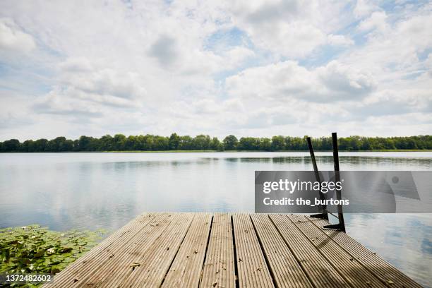 jetty at an idyllic lake - lakeshore stockfoto's en -beelden