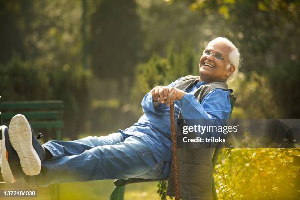 happy senior man sitting at park - feet up stock pictures, royalty-free photos & images