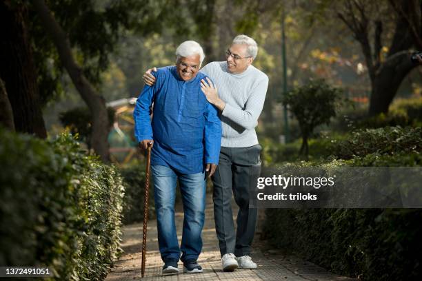 senior man is having knee pain in the park - retirement community staff stock pictures, royalty-free photos & images