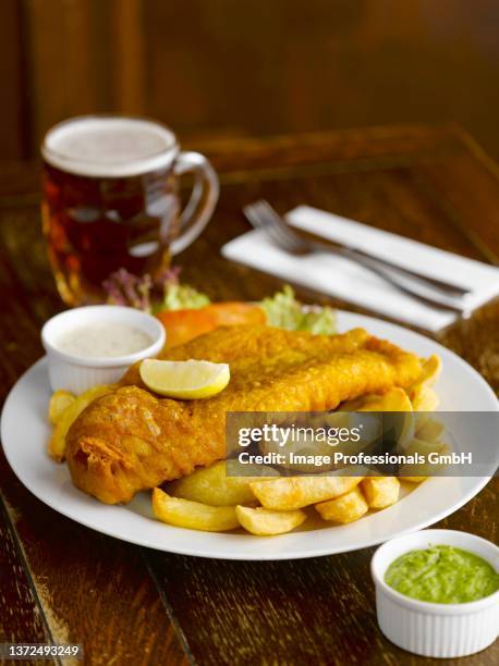 fish and chips with sauces and beer in a pub - ビアホール ストックフォトと画像