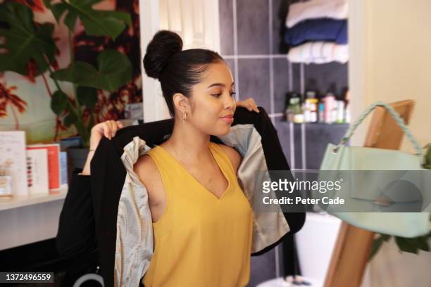 woman putting on smart work jacket - interview preparation stock pictures, royalty-free photos & images