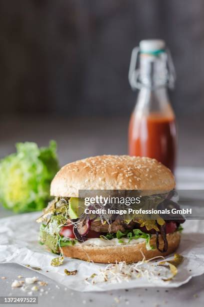 a hamburger with seaweed bacon, bean sprouts and strawberry ketchup - bbq avocado imagens e fotografias de stock