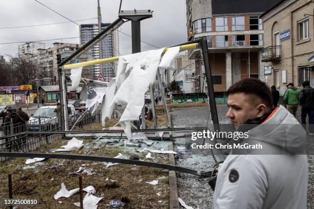 People stand around a damaged structure caused by a rocket on February 24, 2022 in Kyiv, Ukraine. Overnight, Russia began a large-scale attack on...