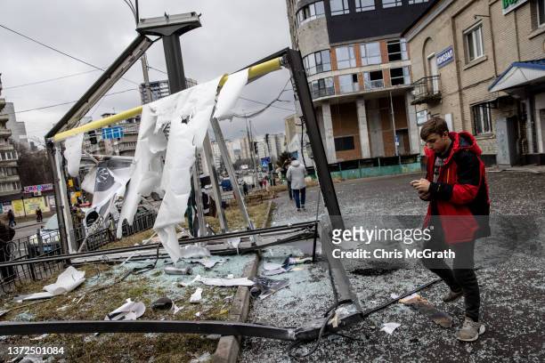 People stand around a damaged structure caused by a rocket on February 24, 2022 in Kyiv, Ukraine. Overnight, Russia began a large-scale attack on...