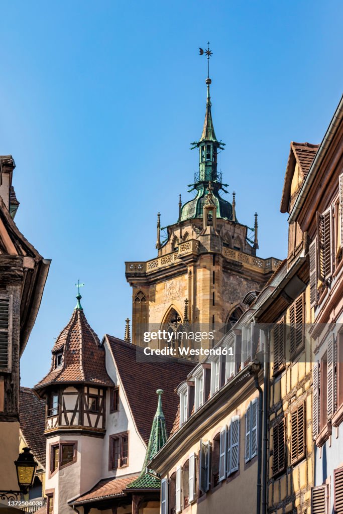 France, Alsace, Colmar, Old town houses with bell tower of Saint Martins Church in background