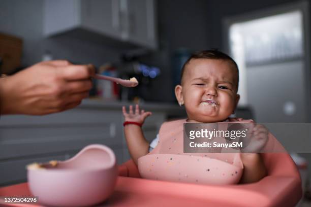 baby sitting in highchair refusing to eat - picky eater stock pictures, royalty-free photos & images