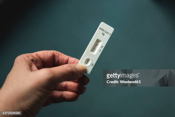 hand of woman holding rapid diagnostic test for covid-19 - positive emotionen stock-fotos und bilder